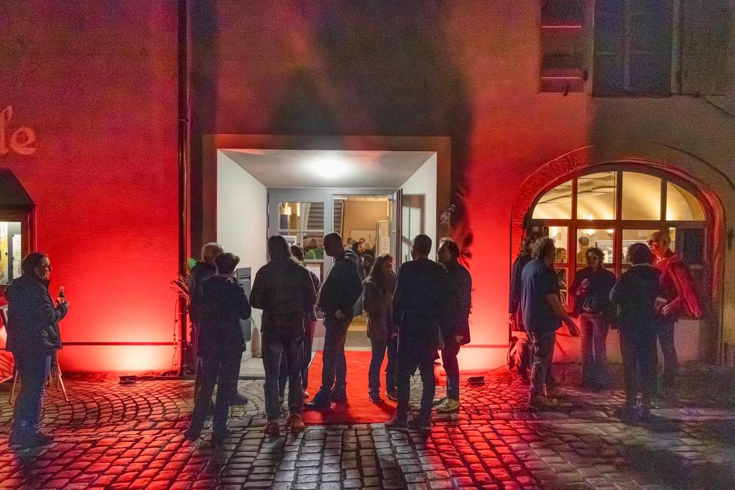 Festival evening outside KulturKino Feuchtwangen, entrance lit in red